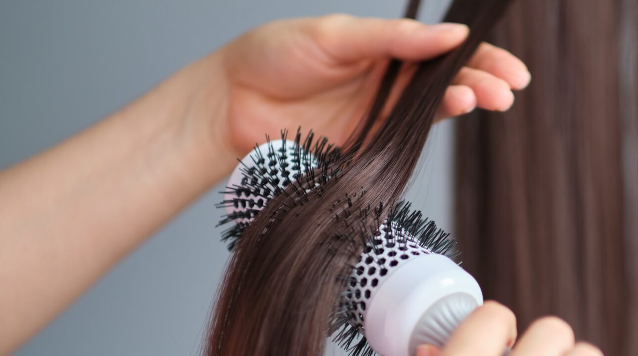 Home Services In Dubai 18 Drying brunette hair with hair dryer and round brush. hair care at home