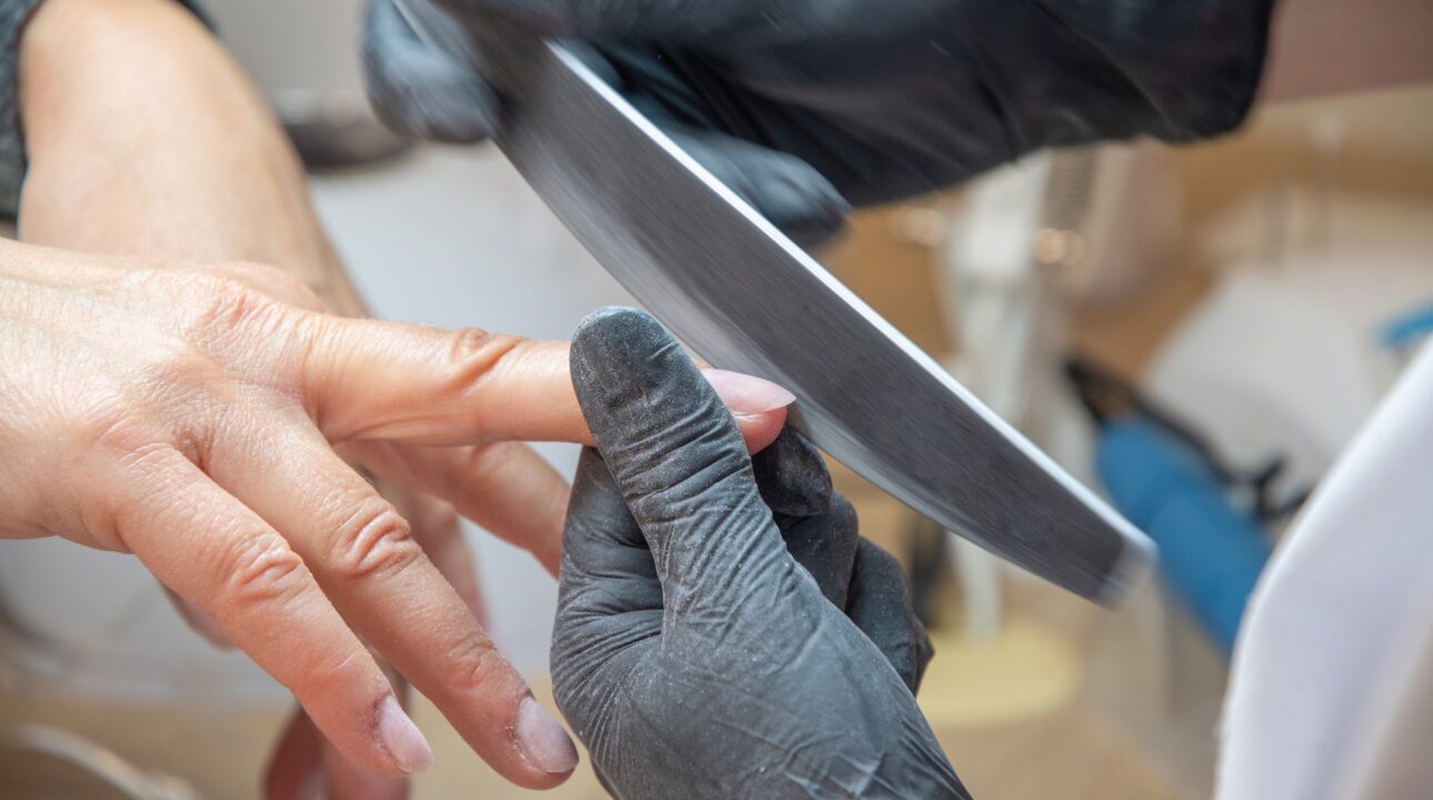 Home Services In Dubai 17 Skilled manicure master using fingernail file while correcting client nail form